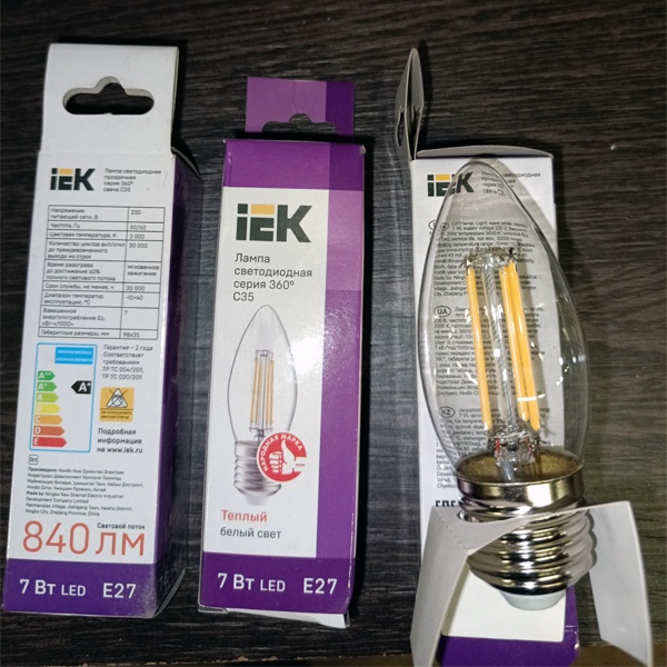 Энергосберегающая LED лампочка свеча с нитевидными светодиодами, мощностью 7 Ватт, с цоколем E27, теплый белый свет, прозрачная колба