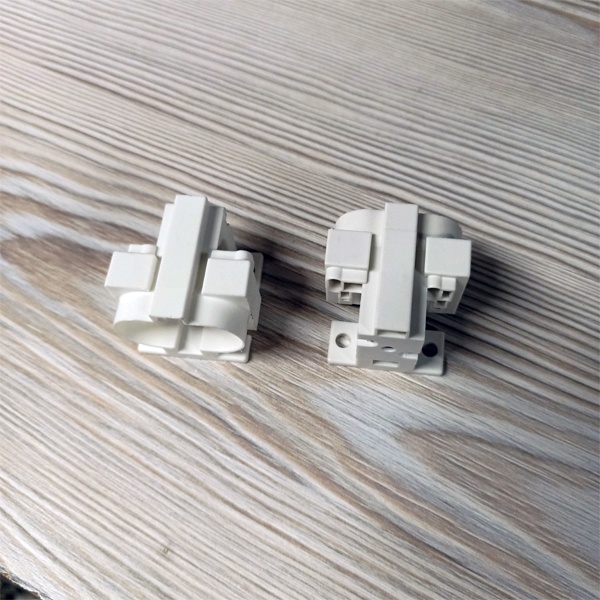 Патрон G23 для компактных люминесцентных ламп с центральным креплением под винт М3 и боковыми креплениями под винт М4 и под саморезы.