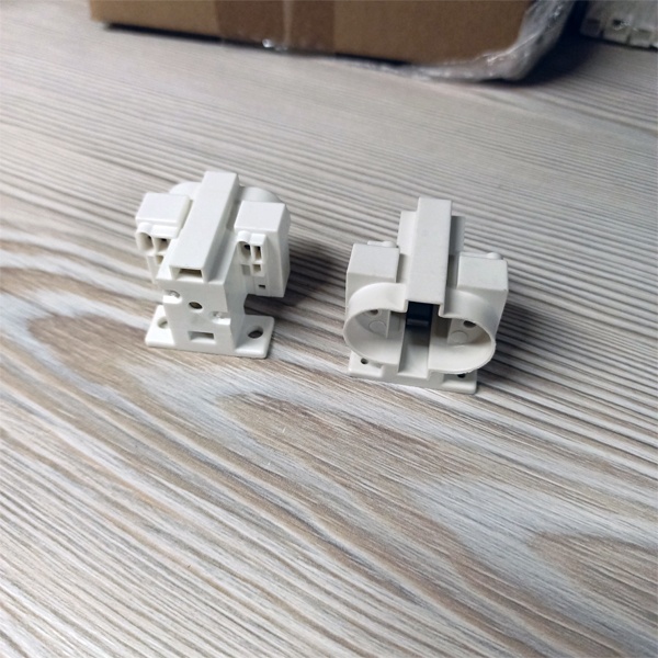 Патрон G23 для компактных люминесцентных ламп с центральным креплением под винт М3 и боковыми креплениями под винт М4 и под саморезы.