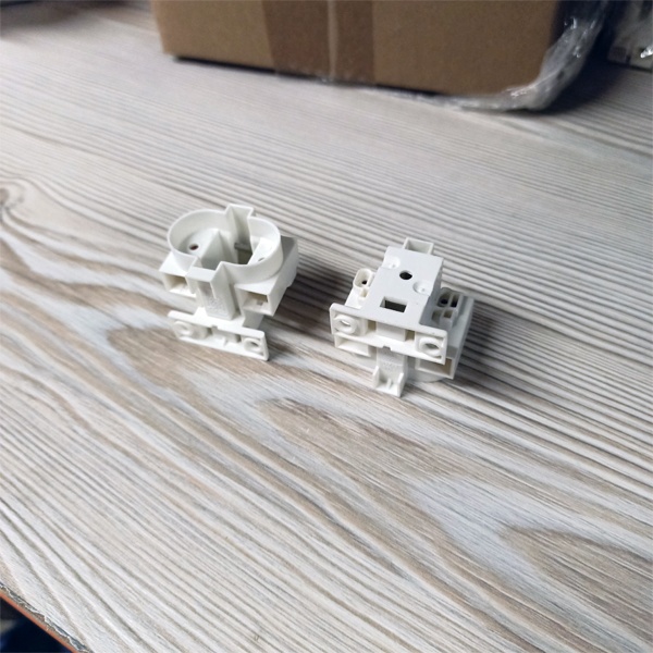 Патрон G23 для компактных люминесцентных ламп с центральным креплением под винт М3 и боковыми креплениями под винт М4.